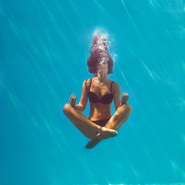 Femme sui fait du yoga dans l'eau